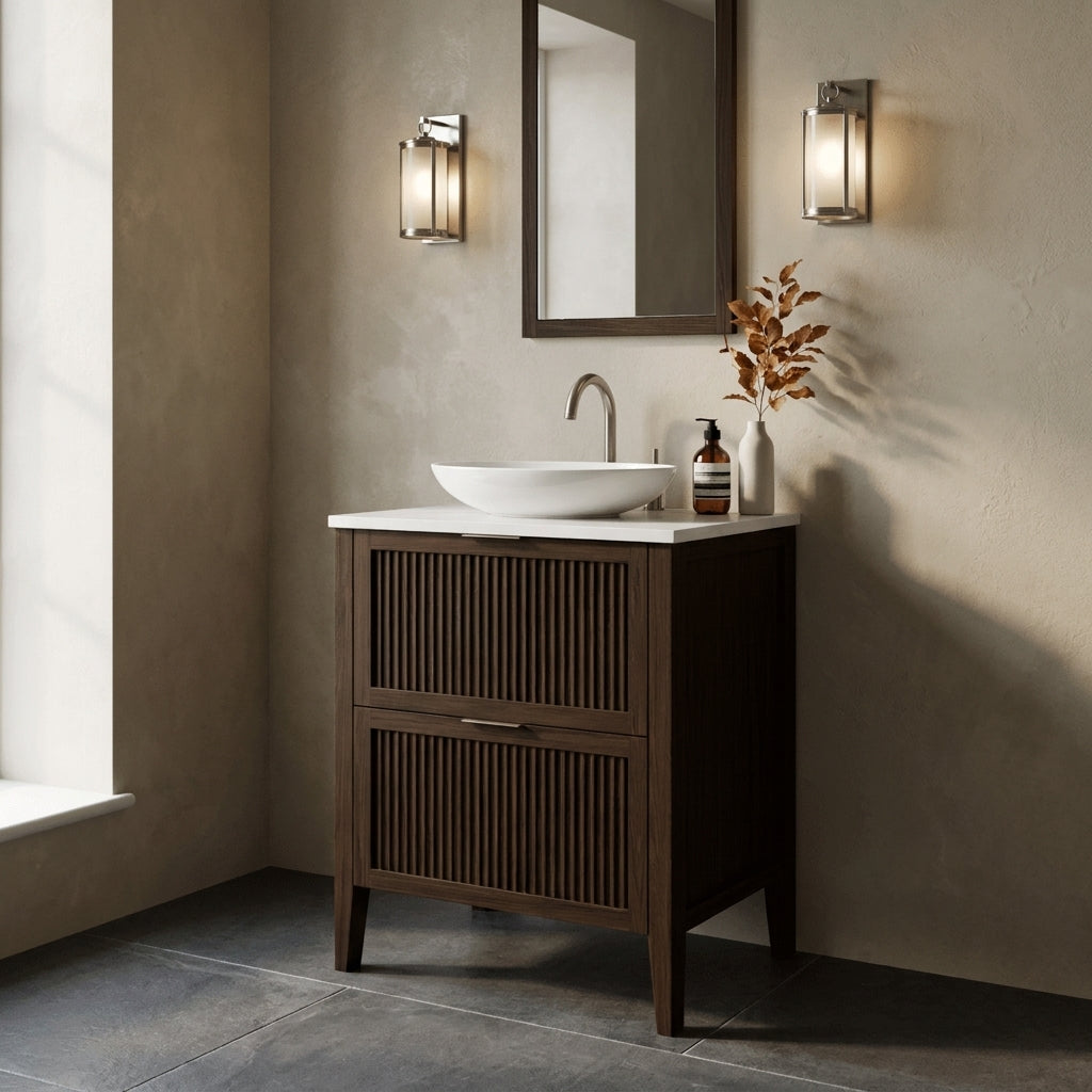 Mockridge Design Clifton 600mm floor-standing single vanity in espresso stained oak with deep warm chocolate-brown grain figuring and vertical fluted drawer fronts set within shaker frame borders, Calacatta quartz worktop, oval ceramic sit-on basin and brushed nickel deck-mounted vessel mixer tap, styled in an enveloping English bathroom with warm rich putty lime-washed plaster walls and honed dark grey limestone floor