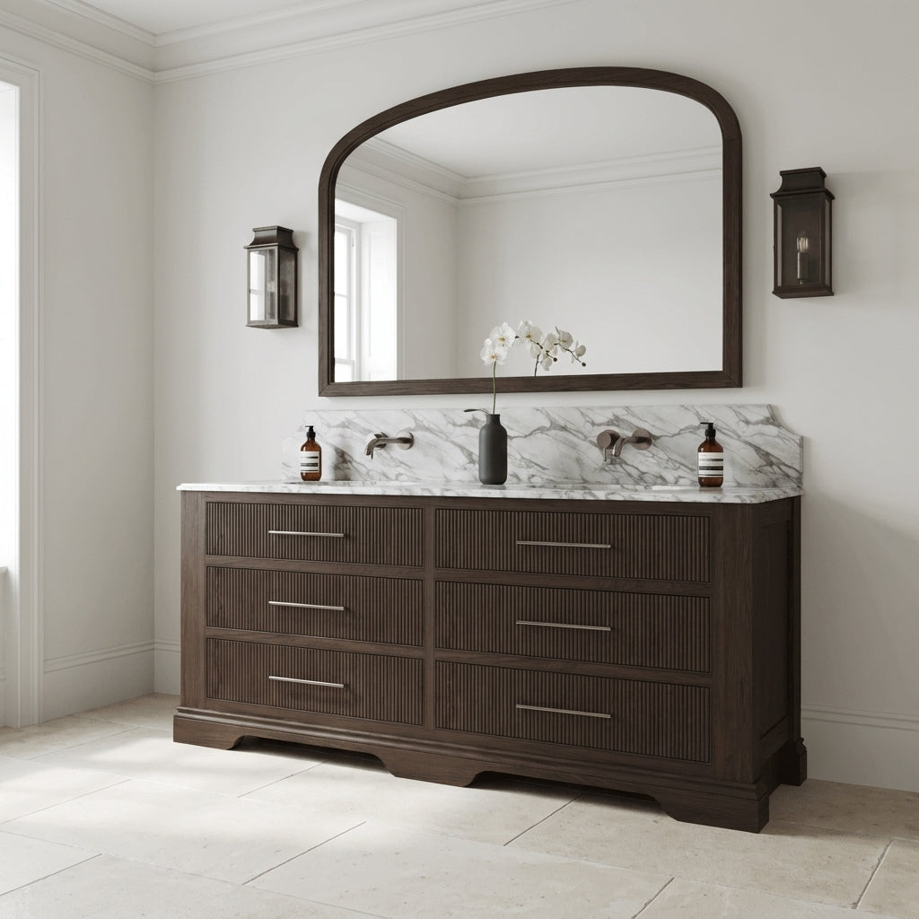 Mockridge Design Kingsbridge 1900mm floor-standing double vanity in Dark Roast stained oak with cool smoky undertone and reeded drawer fronts, dramatic shaped Calacatta marble backsplash, twin undermount basins and twin deep dark patinated brass wall-mounted mixer taps, styled in a deluxe grand traditional English principal bathroom with Farrow and Ball Cornforth White painted walls and honed Crema d'Orcia limestone floor