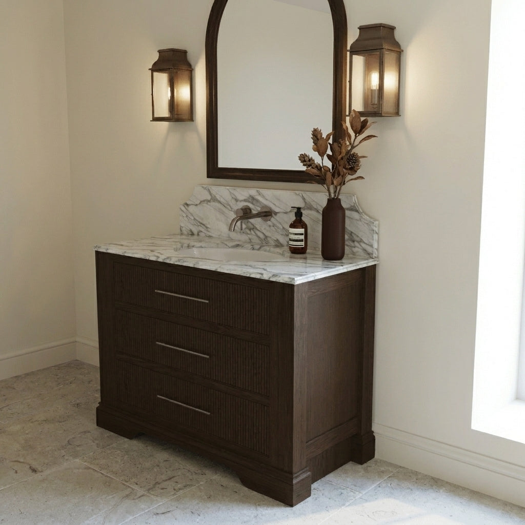 Mockridge Design Kingsbridge 1000mm floor-standing single vanity in Espresso stained oak with near-black depth and visible grain figuring and reeded drawer fronts, dramatic shaped Calacatta marble backsplash, oval undermount basin and deep antiqued bronze wall-mounted mixer tap, styled in a deluxe grand traditional English bathroom with Farrow and Ball Pointing painted walls and honed Jura limestone floor